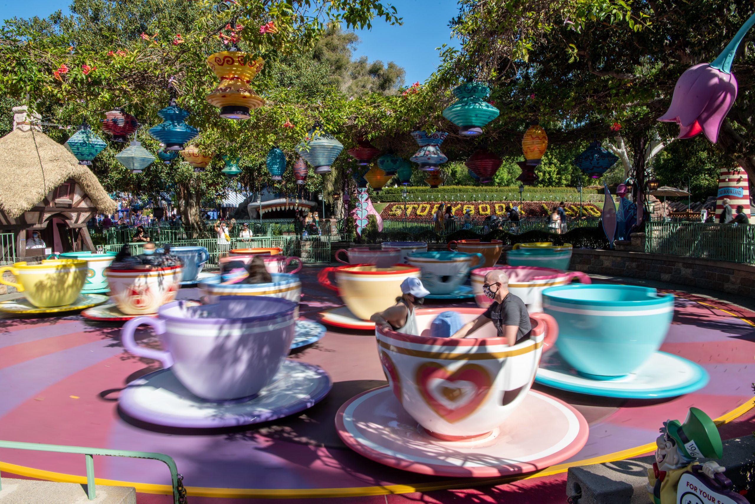 Teacups spin rapidly in a colorful amusement park ride, surrounded by vibrant lanterns and trees. Text reads: "STORYBOOK."