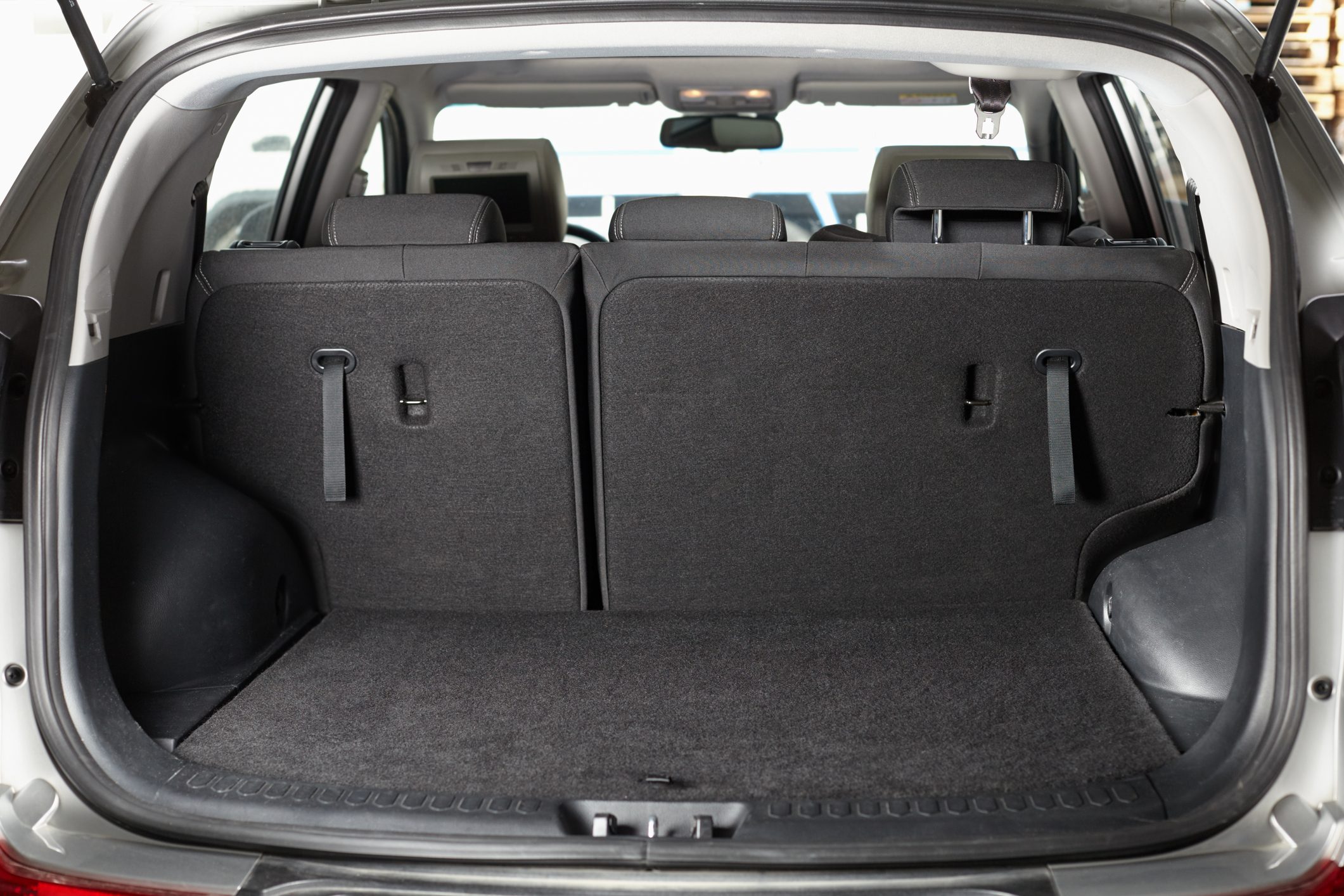 Car trunk with rear seats upright, viewed from the back, inside a vehicle interior.
