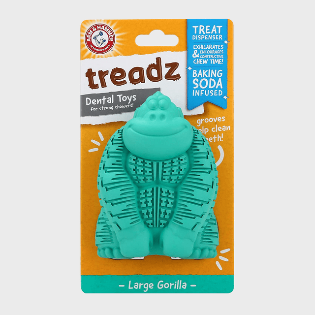 Turquoise gorilla-shaped toy sits in packaging; it acts as a dental chew for dogs. Text reads 