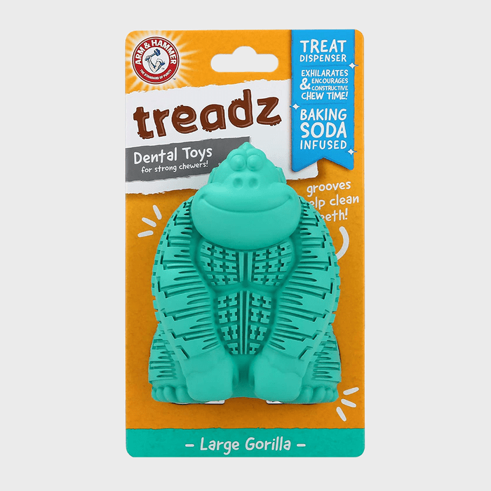 Turquoise gorilla-shaped toy sits in packaging; it acts as a dental chew for dogs. Text reads 