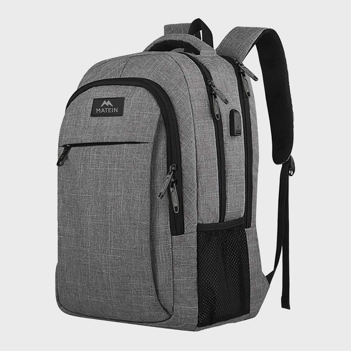 Backpack stands upright, featuring multiple compartments and zippers, with a USB port on the side. Text reads: 