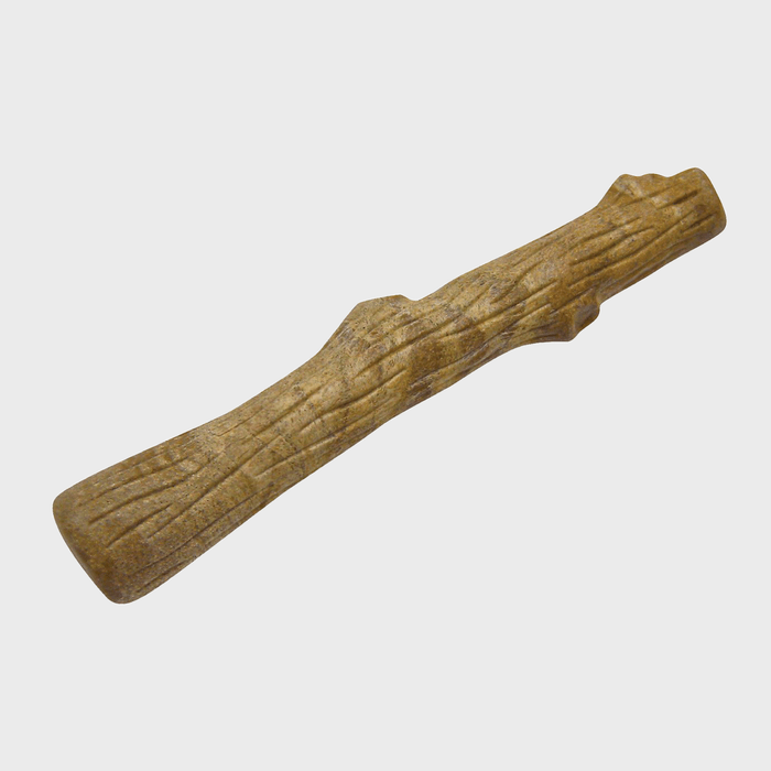 Carved wooden stick rests on a plain white background, displaying detailed grooves and texture resembling bark.