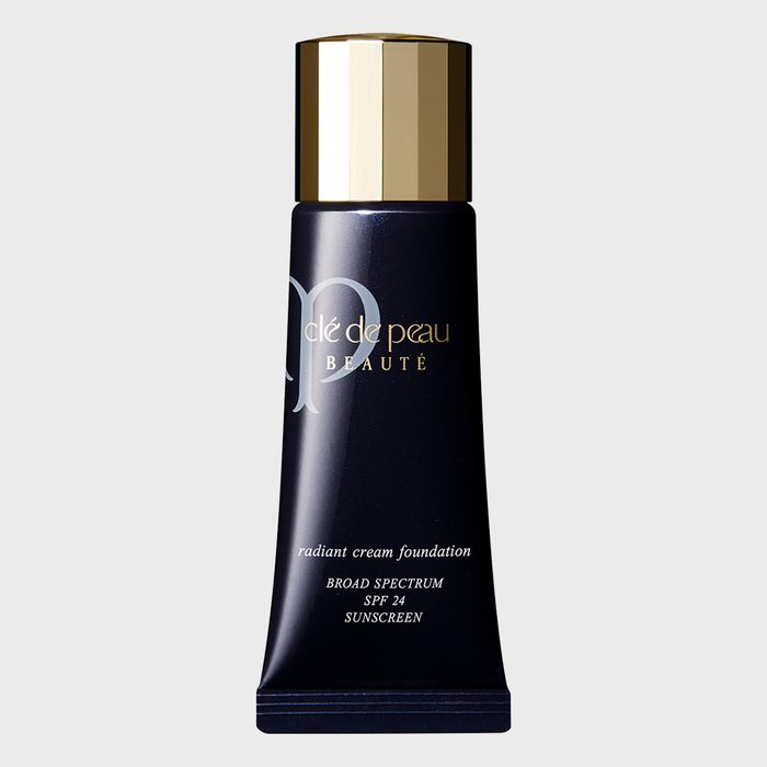 Tube stands upright displaying â€œclÃ© de peau BEAUTÃ‰,â€ labeled as radiant cream foundation with SPF 24 sunscreen, on a plain light gray background.