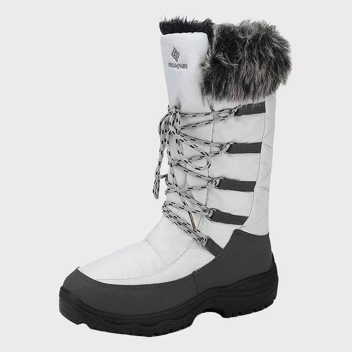 A white winter boot with gray sole, fur trim, and patterned laces; set against a plain background. Text: 