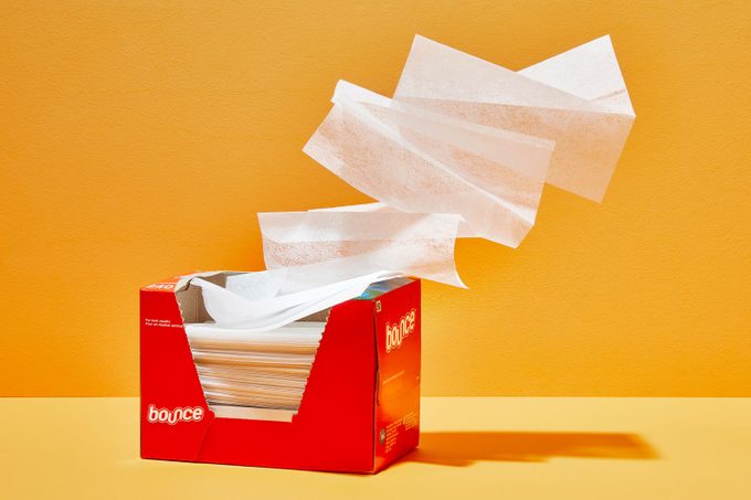 dryer sheets flying out of dryer sheet box on orange background