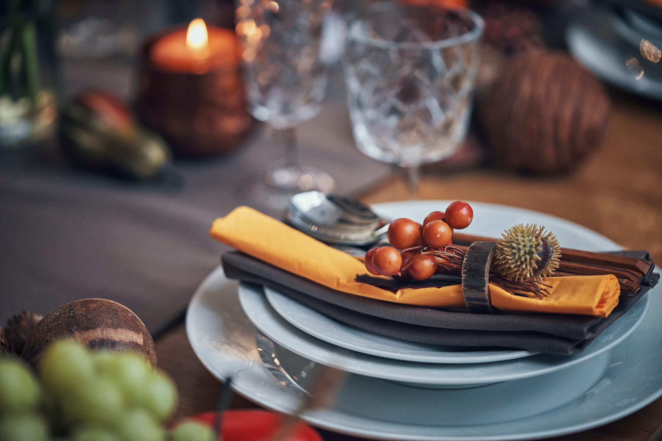 Decorated Table for Thanksgiving Dinner with Candles, Pumpkins, Leafs and Nuts