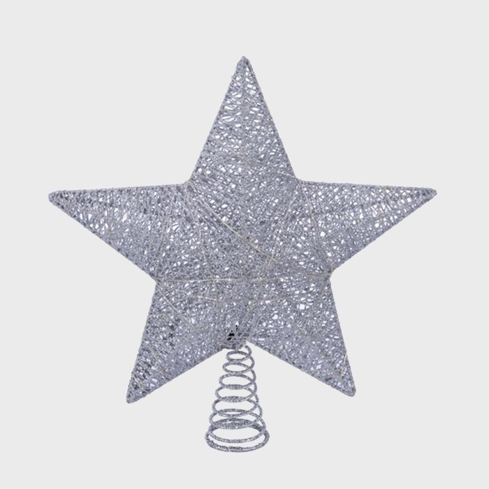 Silver wire star stands upright on a coiled spring base against plain background.