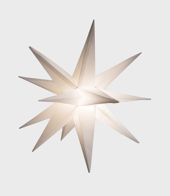 A white geometric star emits soft light, hovering against a plain gray background.