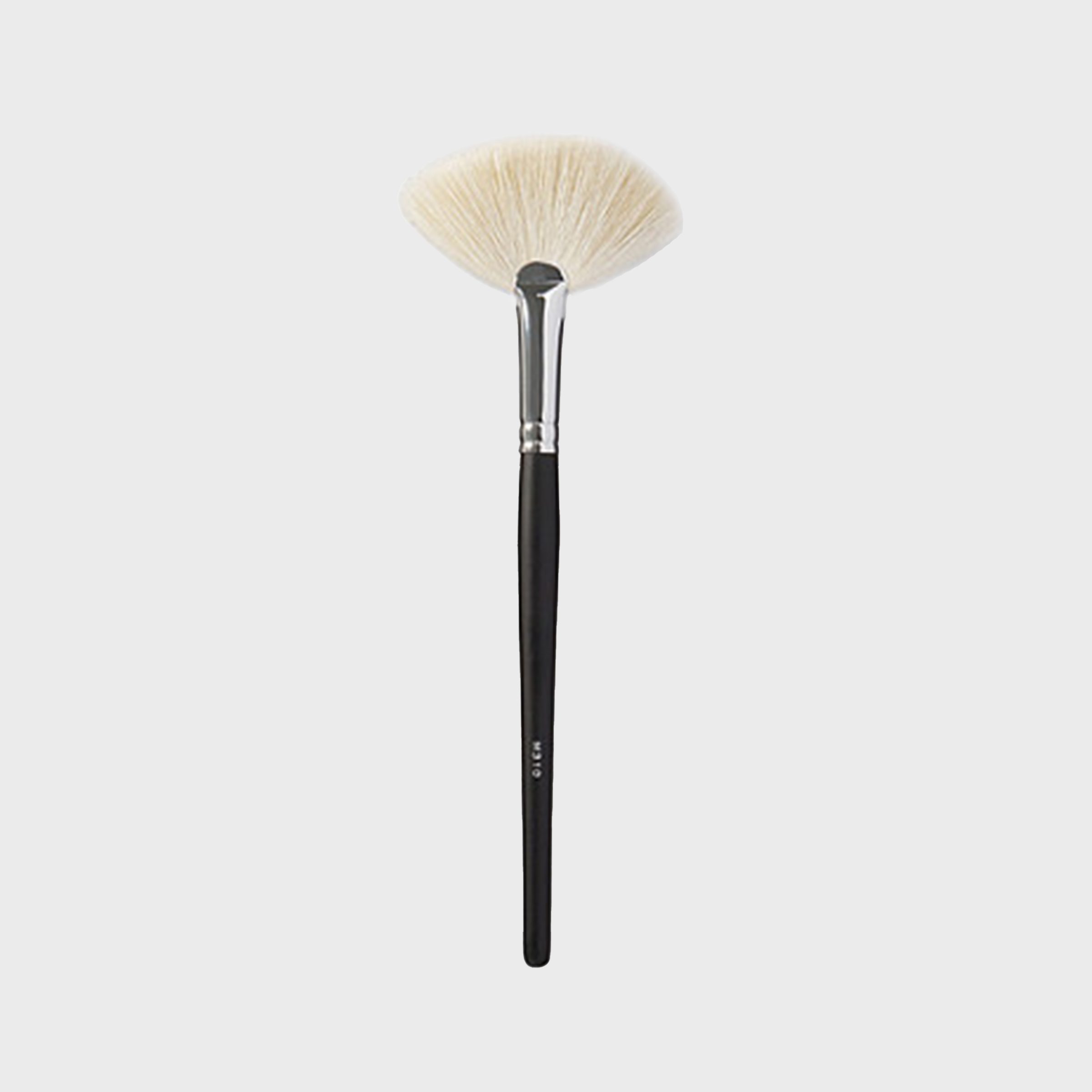 A fan brush sits against a plain background, showcasing its light bristles and dark handle, ideal for makeup application or delicate dusting.