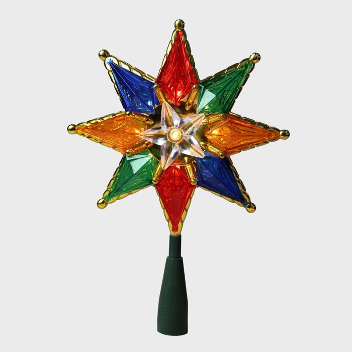 Multicolored star-shaped tree topper, featuring red, blue, green, and gold segments. It stands upright against a plain white background.