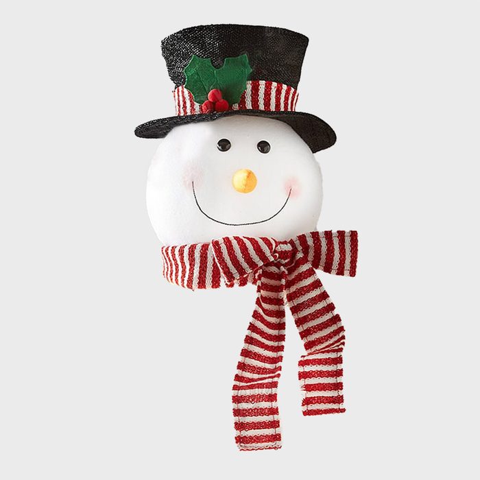 Snowman decoration smiling with holly-adorned hat, wearing a red-striped scarf; set against a plain background.