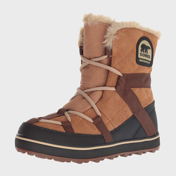 Tan winter boot with fur trim, laced up, featuring black base and logo indicating waterproof quality, against a plain white background.
