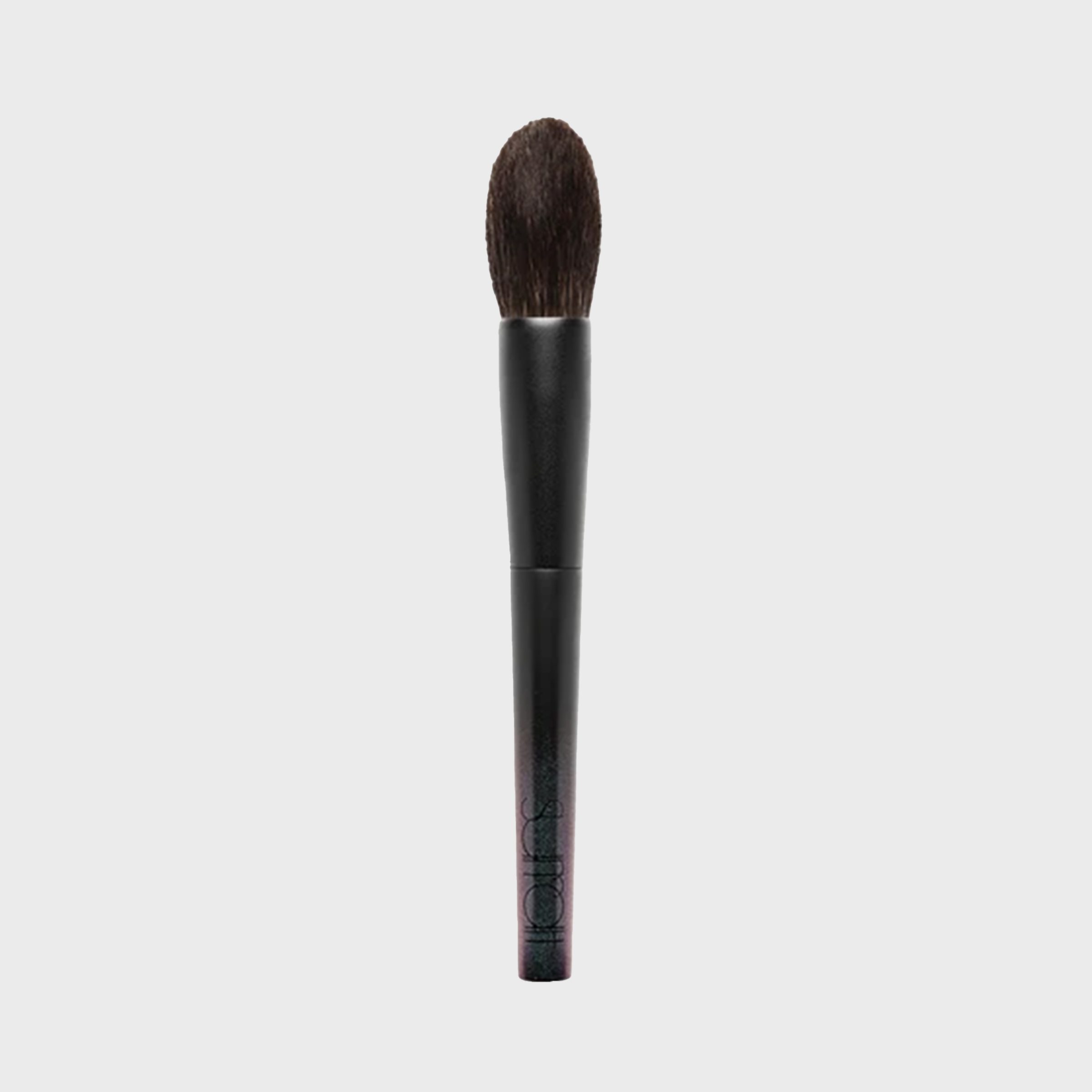 Makeup brush stands upright against a plain background; featuring a dark handle and fluffy bristles.
