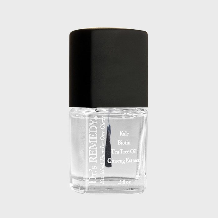 Clear nail polish in a square bottle sits with a black cap, labeled 