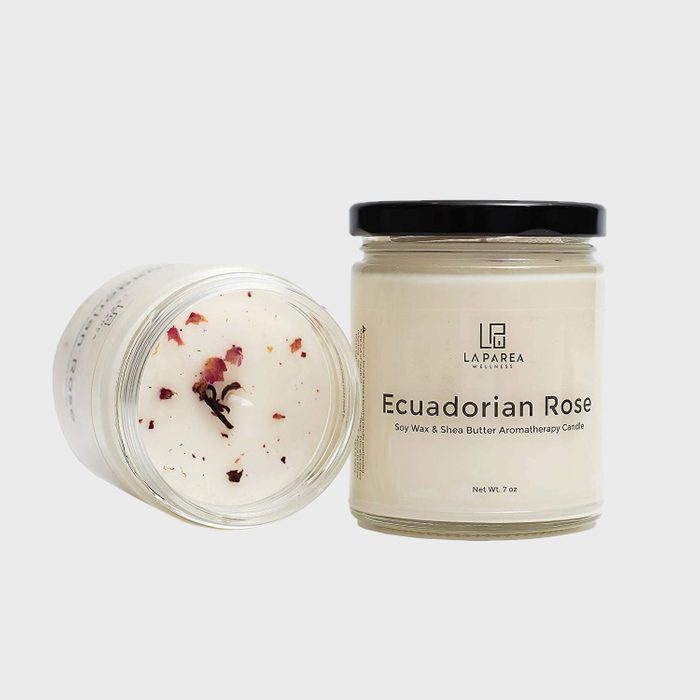 Candles in glass jars, one upright, one lying, with rose petals, labeled 