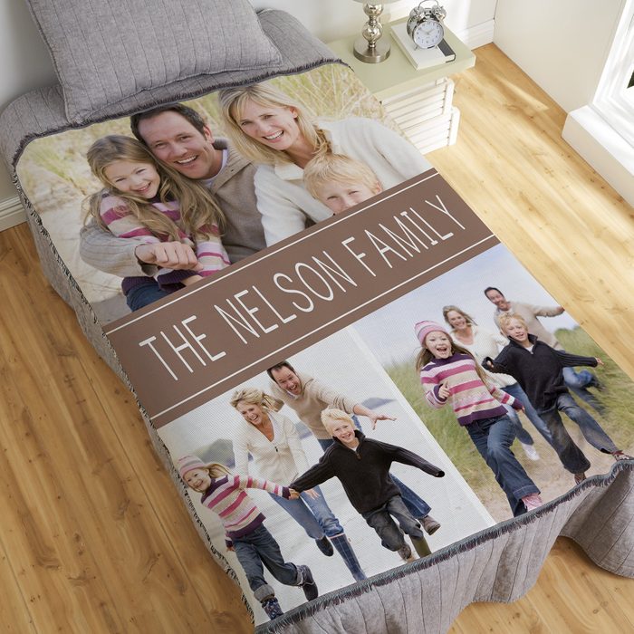 Blanket covers bed displaying family photos with 