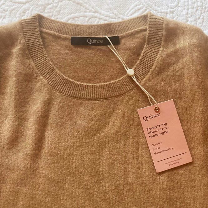 Sweater laying flat with a tag; labeled 