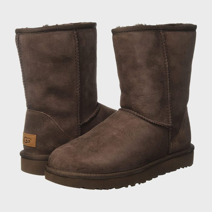 Brown suede boots sitting upright, displaying stitched seams and rounded toes, against a plain white background. Text reads 