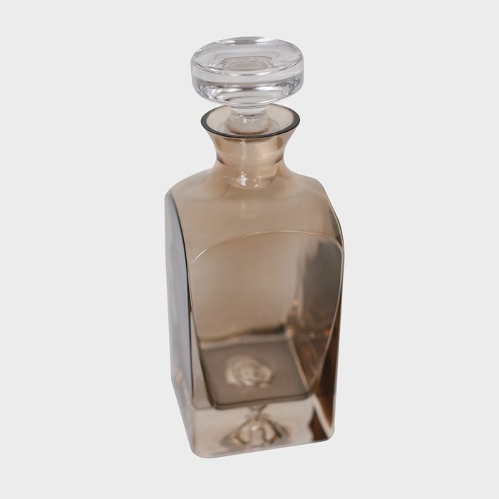 Glass bottle with a clear stopper; stands upright against a plain, white background.