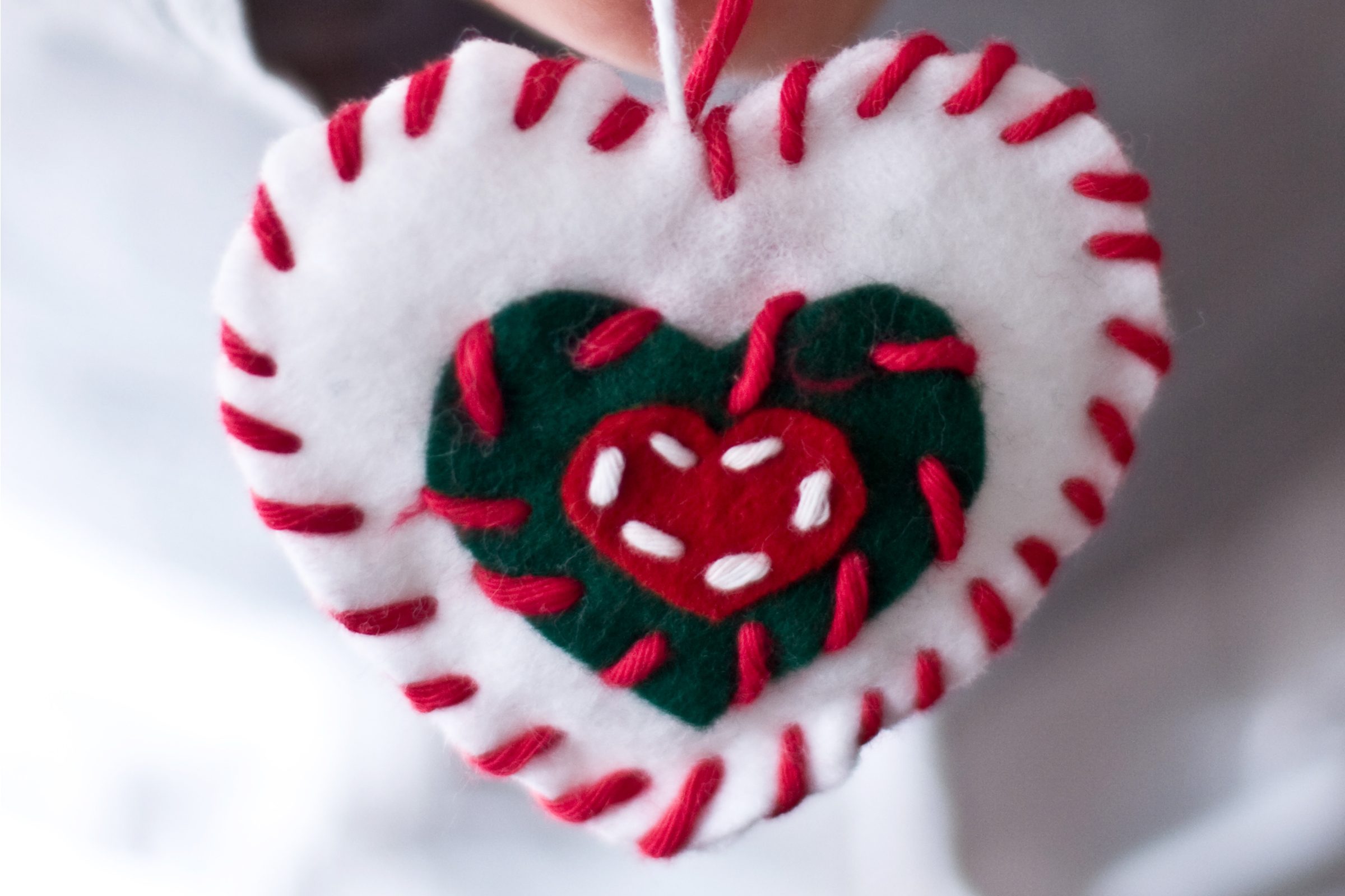 Little girl holding a heart made of felt