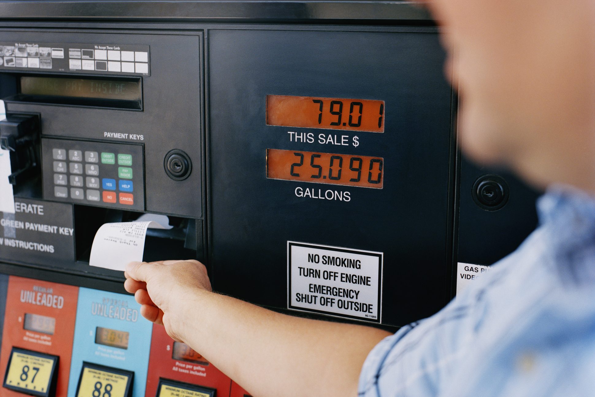 Man getting receipt from gas pump