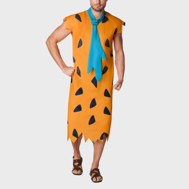 Person wearing an orange, black-spotted tunic with a blue tie, standing against a plain background.