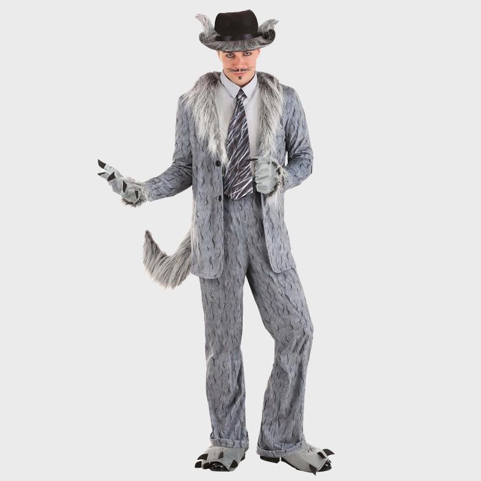 Person dressed in a furry wolf-themed suit, holding a cigar, wearing a black hat, in front of a plain white background.