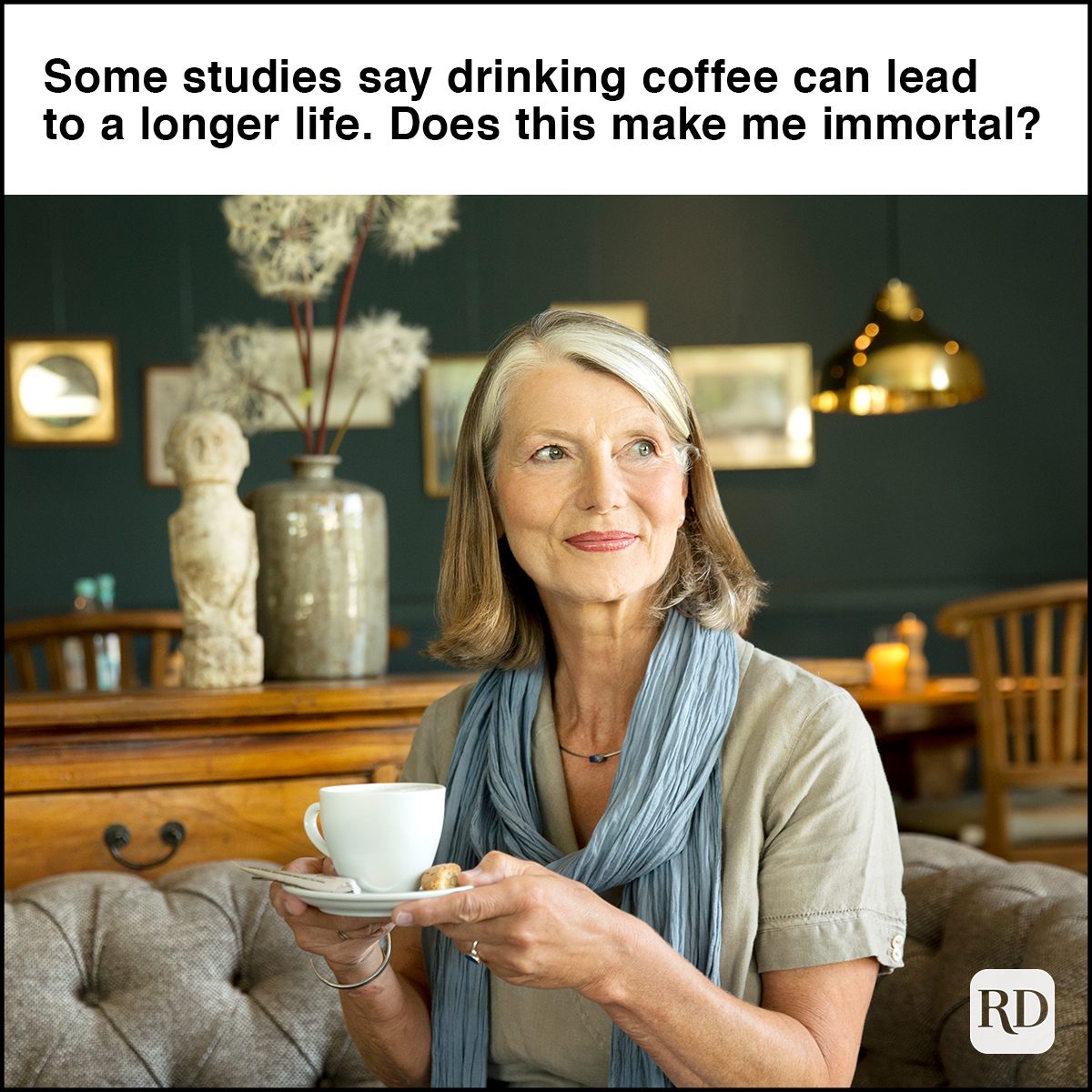 Smiling senior woman in lounge room with cup of coffee 