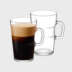 Glass mug holds creamy espresso, sits beside an empty identical mug, against a plain gray background.