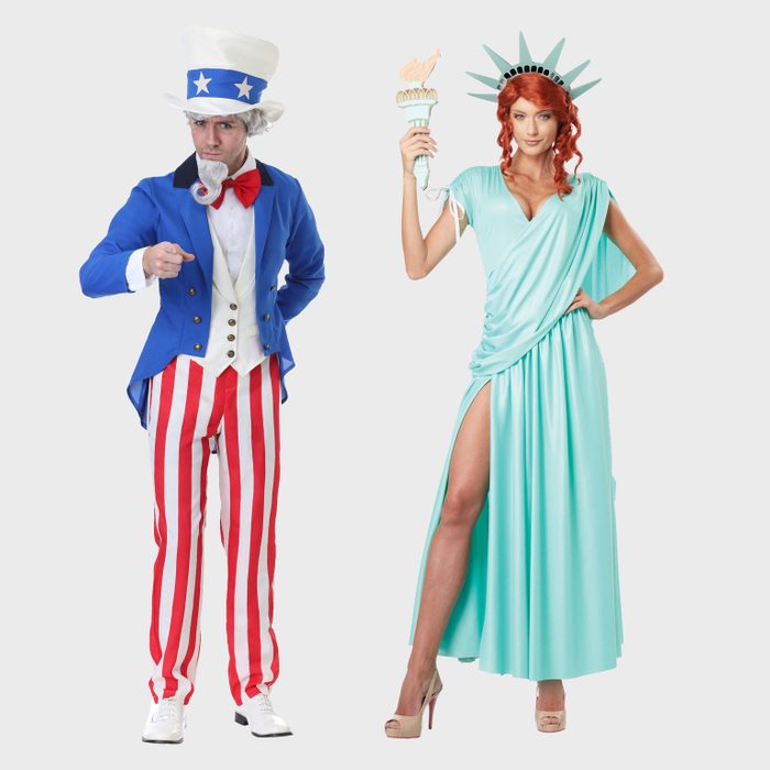 A man dressed as Uncle Sam is pointing, and a woman dressed as the Statue of Liberty holds a torch. Both stand against a plain background.