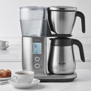 Coffee maker brews on a kitchen countertop; digital display shows 