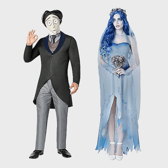 Man gestures in a suit; woman stands in tattered blue dress, holding flowers. Both in costume theme against a plain background.