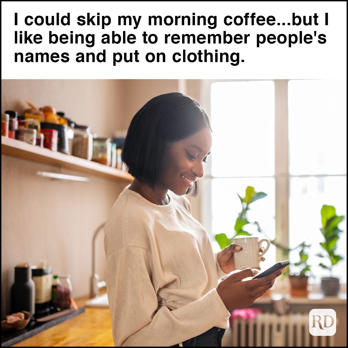 Woman having coffee and texting on her phone at home 