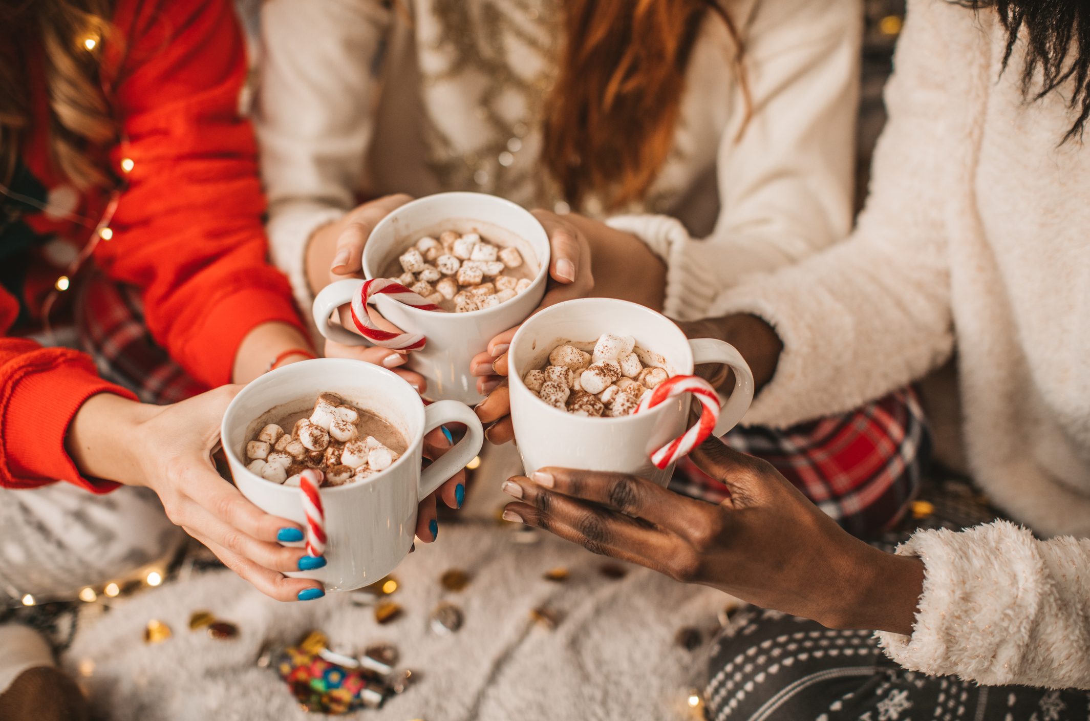 three girls drinking hot cocoa while having a christmas slumber party