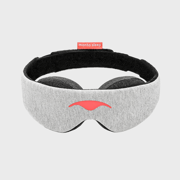 Sleep mask resting upright, displaying red logo on the front, against a plain gray background. 