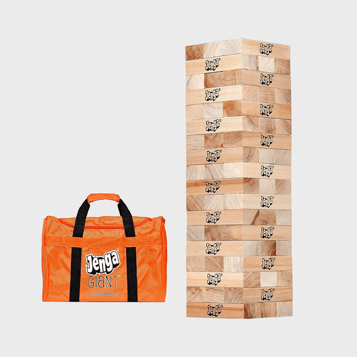 A stacked Jenga tower stands beside an orange carrying bag with 