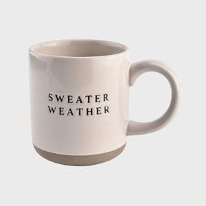 A cream ceramic mug displays the text 