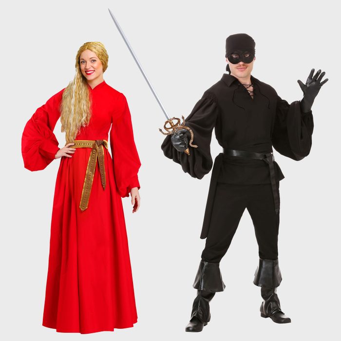 Two people in costume; one in a flowing red dress, the other in black holding a sword, both against a plain background.