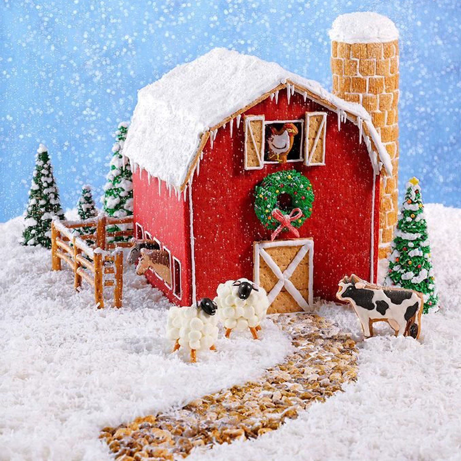 Gingerbread barn displays festive scene with icing snow, sheep, cow, and decor. Nestled among snowy trees, a path leads to the door.