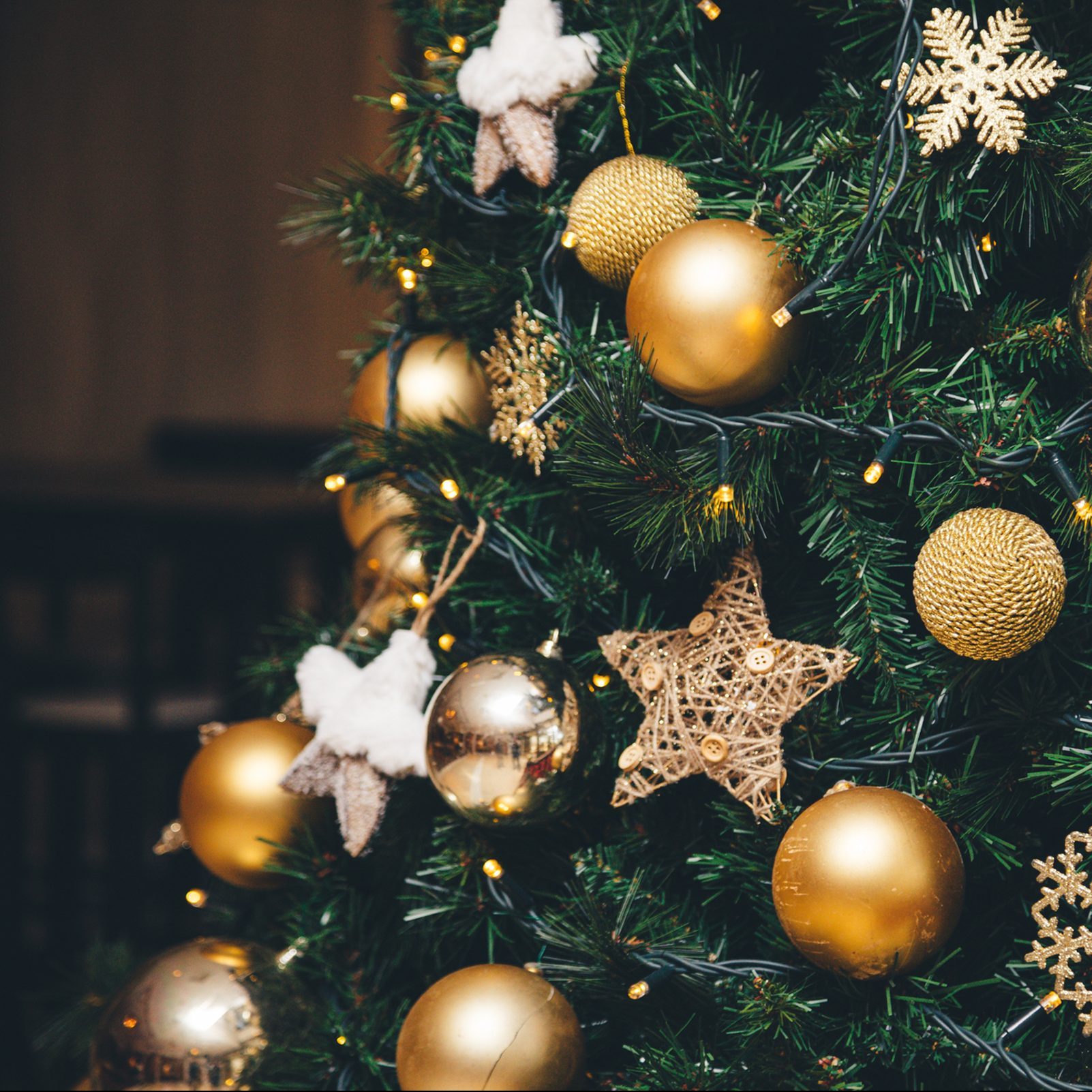 Background of fluffy branches green color New Year trees decorated with beautiful golden shiny sphere balls, toys and ornates