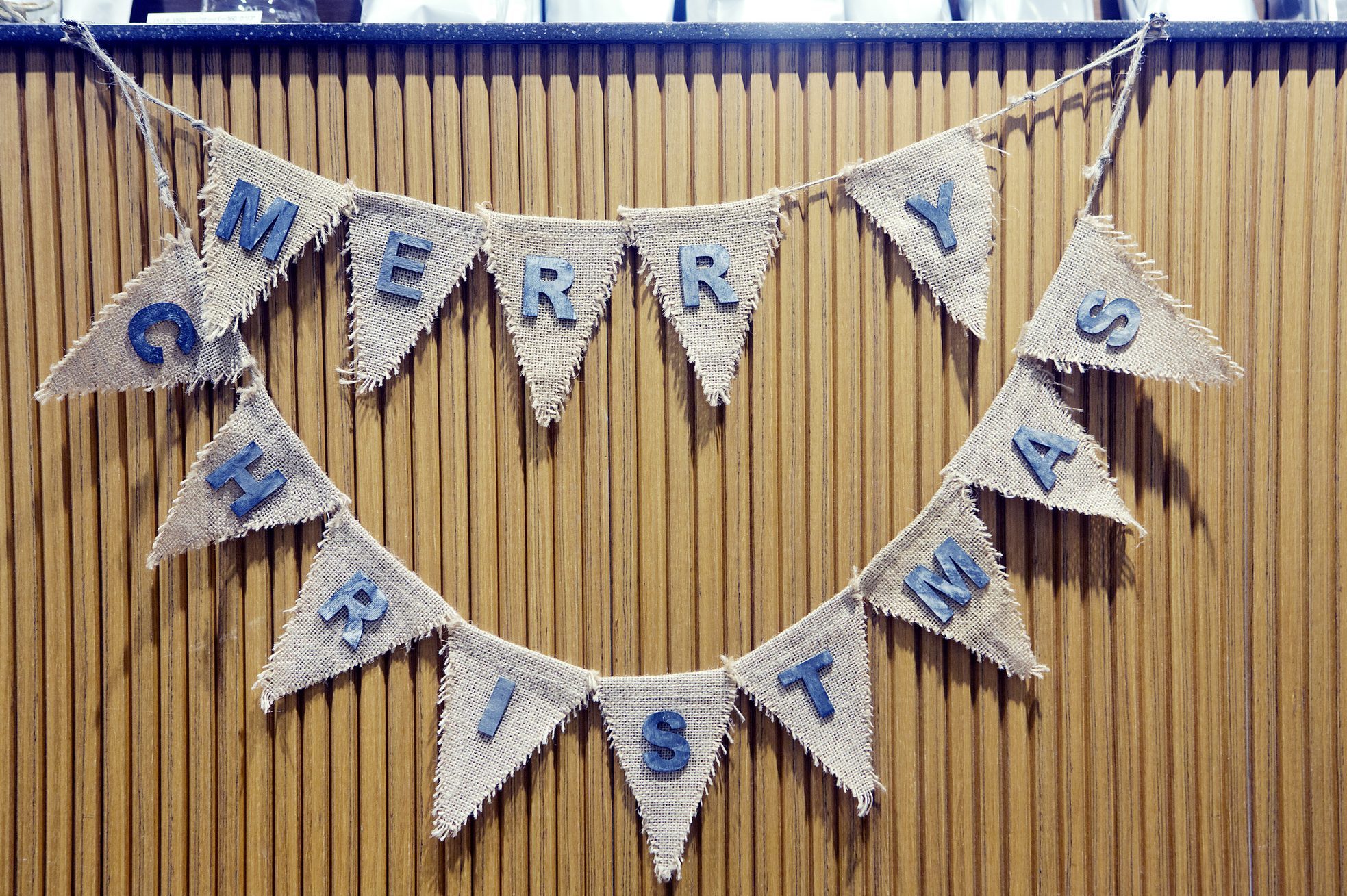 “Merry Christmas” banner decoration against wood counter