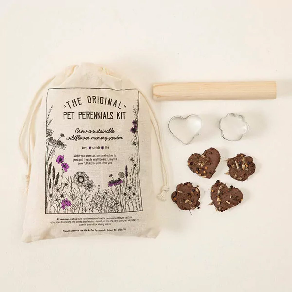 Kit includes drawstring bag, two cookie cutters, rolling pin, and heart-shaped seed pastries, set against a plain background. Bag labeled "The Original Pet Perennials Kit."