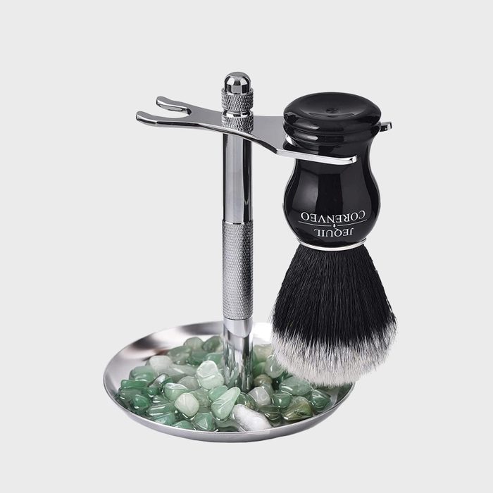 Shaving brush hangs on a metal stand above green and white stones in a silver dish. Text on brush: 