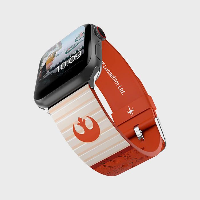 Smartwatch displaying time, resting on a red and white band with a logo. Text reads 