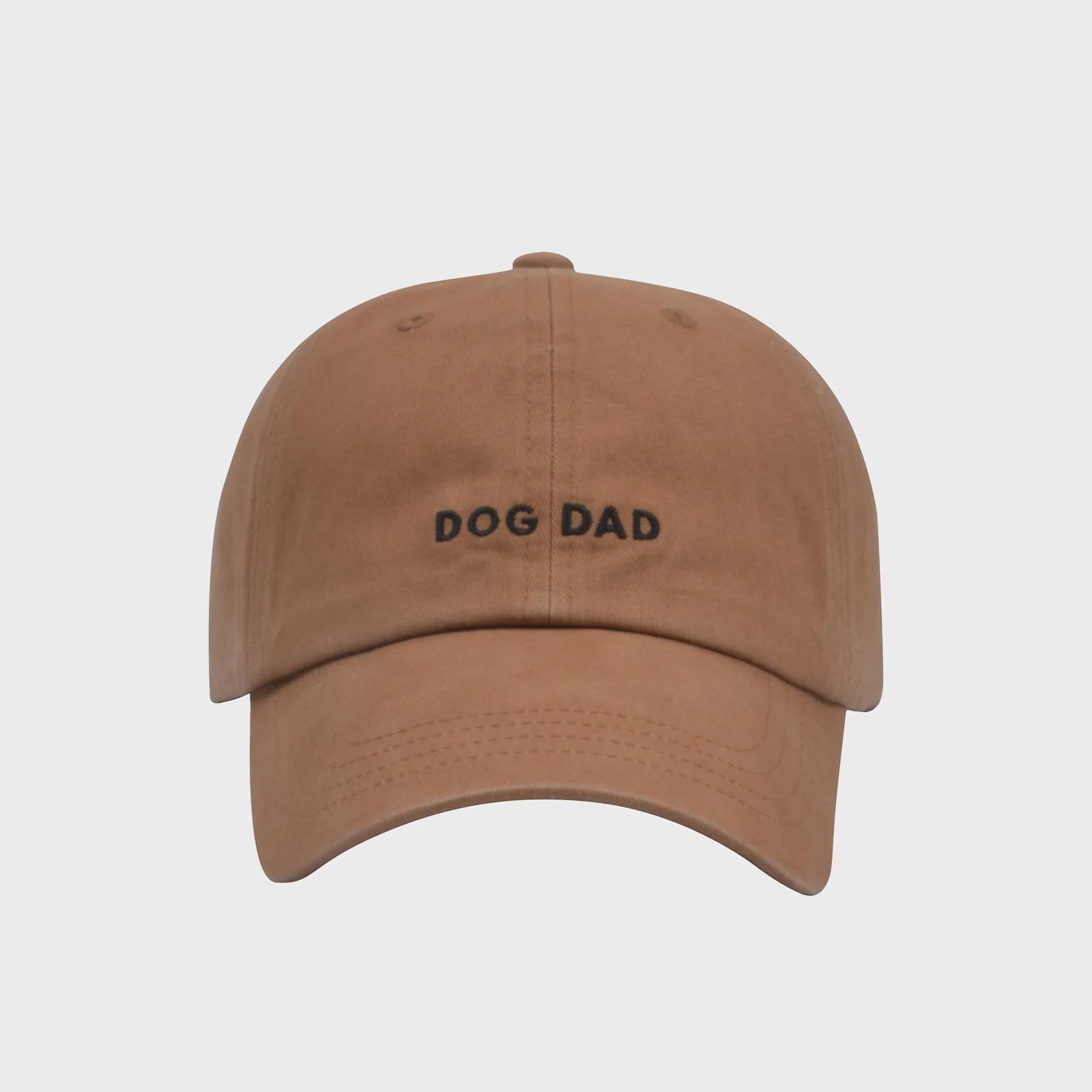 Brown baseball cap displays â€œDOG DADâ€ in black text centered, set against a plain, light gray background.