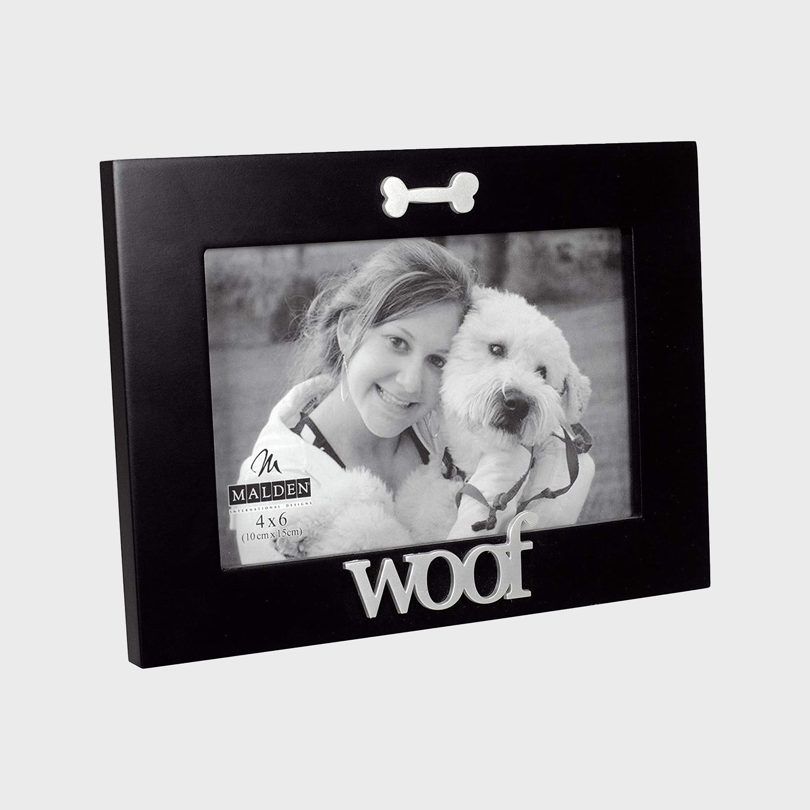Black photo frame displays person hugging fluffy dog outdoors, features bone decoration and "woof" text. Frame size is "4 x 6 (10 cm x 15 cm)."