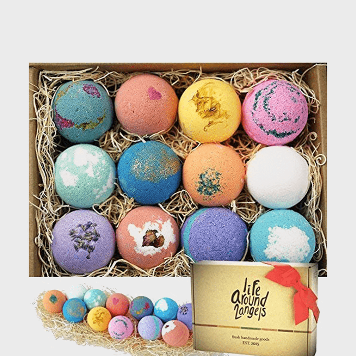 Bath bombs rest on straw in a box, featuring vibrant colors and patterns. Text reads 