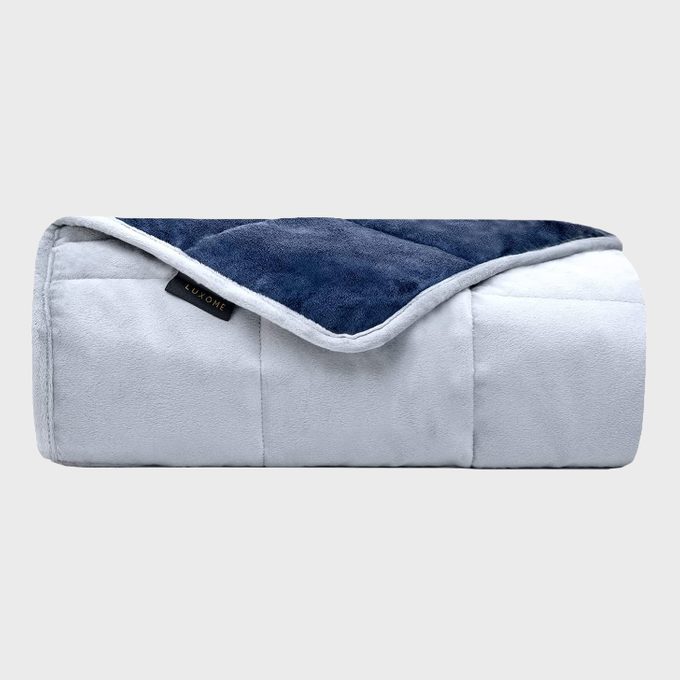 Blanket is rolled neatly; navy and light gray fabric is visible. A small black tag reads 