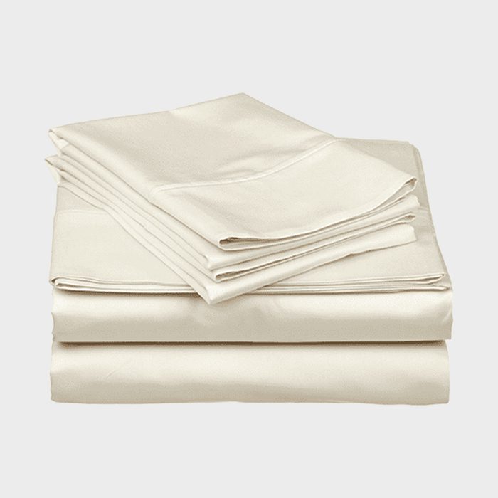A neatly stacked set of cream-colored bed sheets lies on a plain white background.