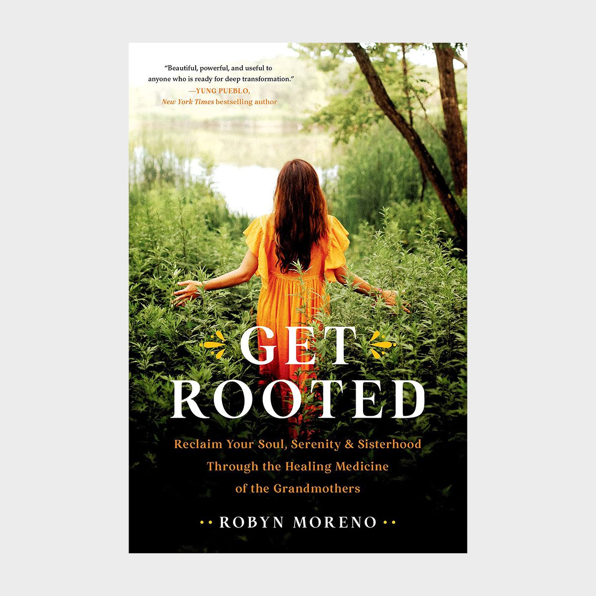 A woman stands with arms outstretched among tall grass, facing a lake. The book title is "Get Rooted" by Robyn Moreno.